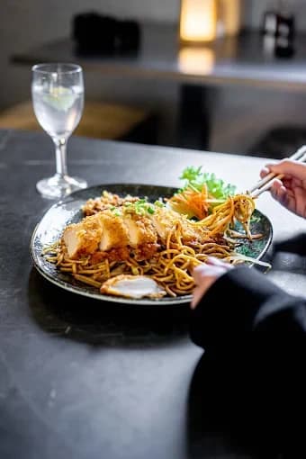 Gebratene Nudeln aus dem Wok mit paniertem Hähnchen